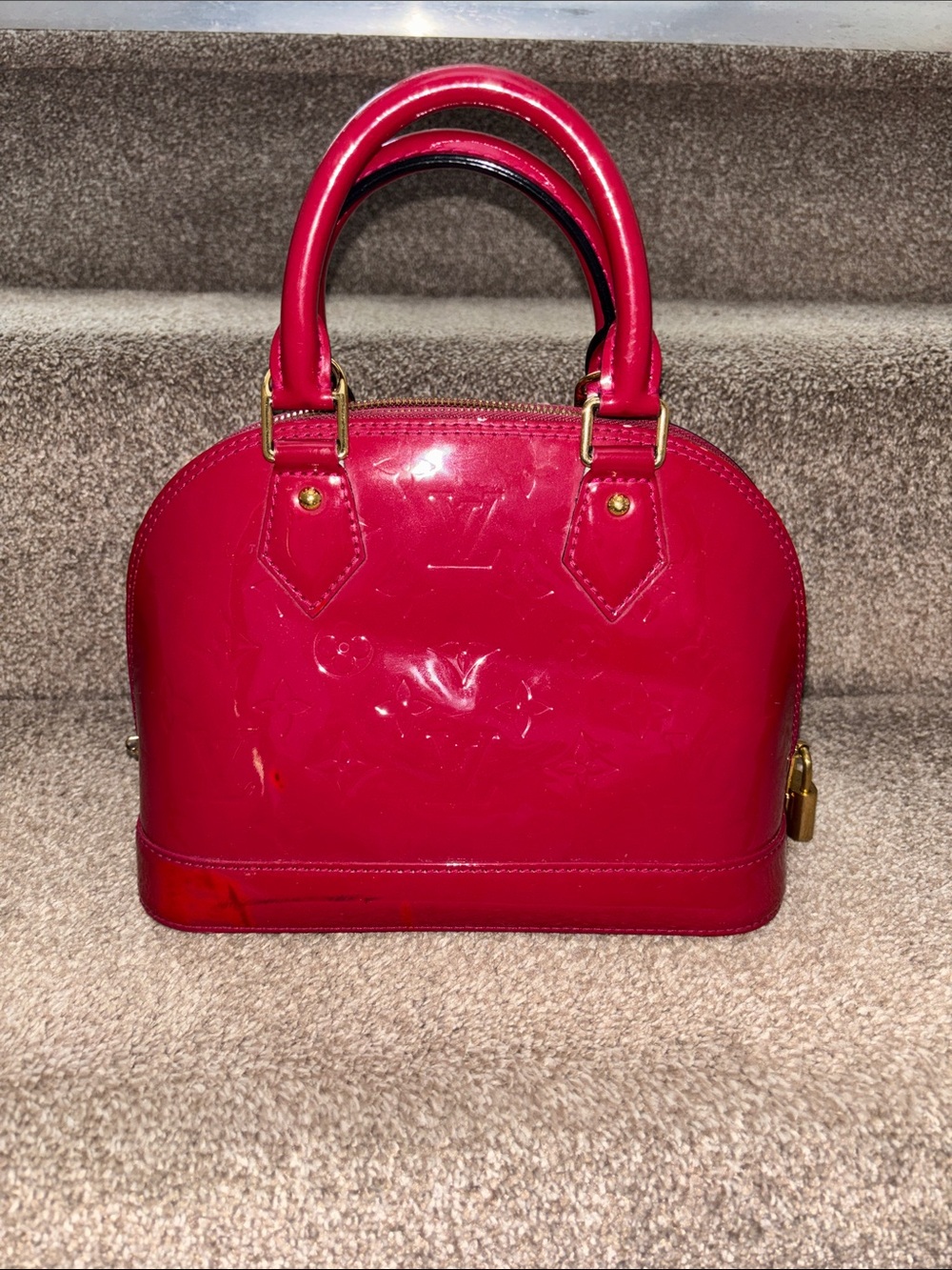 Red Louis Vuitton Alma BB crafted from glossy Monogram Vernis patent leather